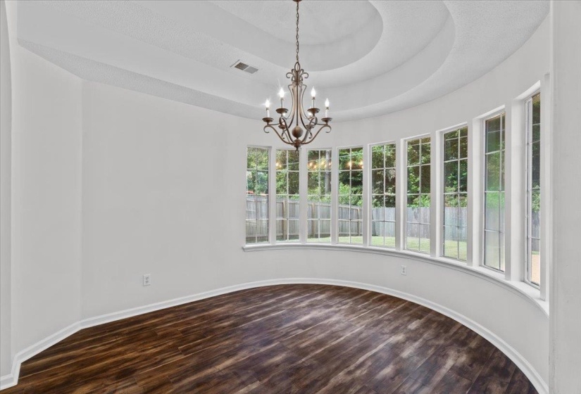 Stairs with arched walkways, a textured ceiling, and wood finished floors