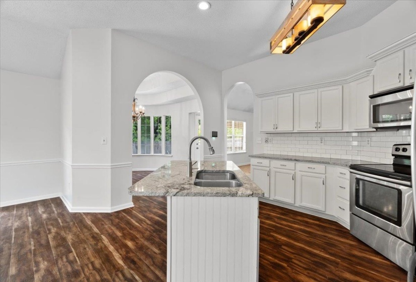 Unfurnished living room featuring lofted ceiling, ceiling fan, a textured ceiling, light tile patterned floors, and a fireplace