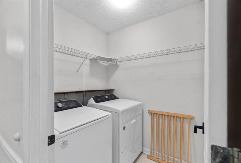 Kitchen with stainless steel appliances, dark wood-type flooring, white cabinetry, and decorative backsplash