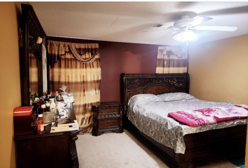 Carpeted bedroom with ceiling fan