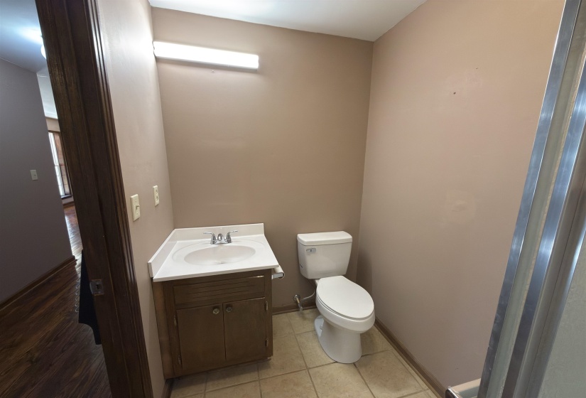 Half bathroom featuring vanity, light tile patterned floors, and healthy amount of natural light