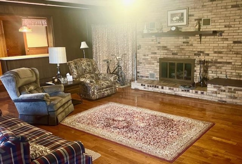 Living area with a fireplace and wood-type flooring