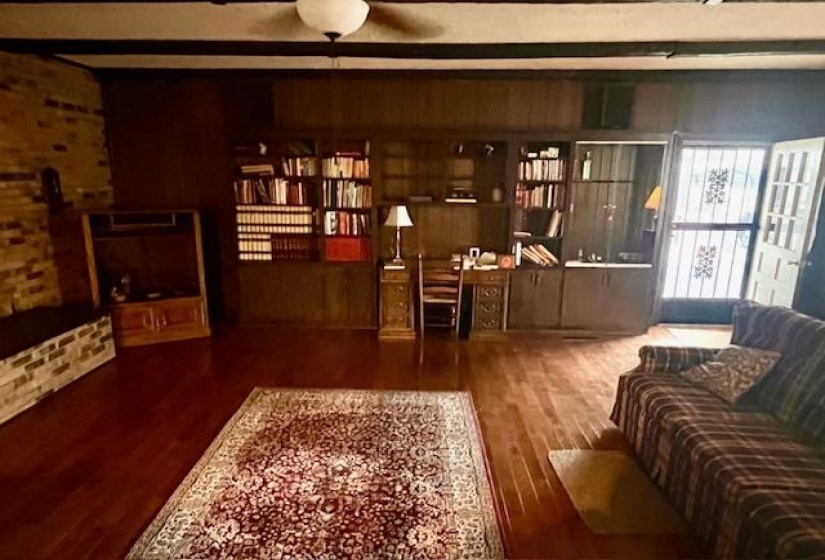 Living room featuring beam ceiling, ceiling fan, and hardwood / wood-style floors