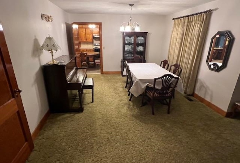 Dining area with light carpet and an inviting chandelier