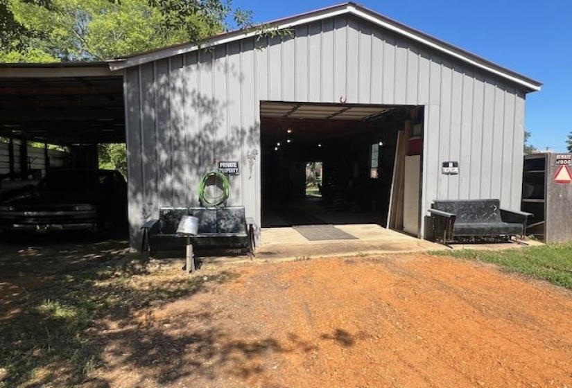 View of outbuilding featuring a carport and a garage