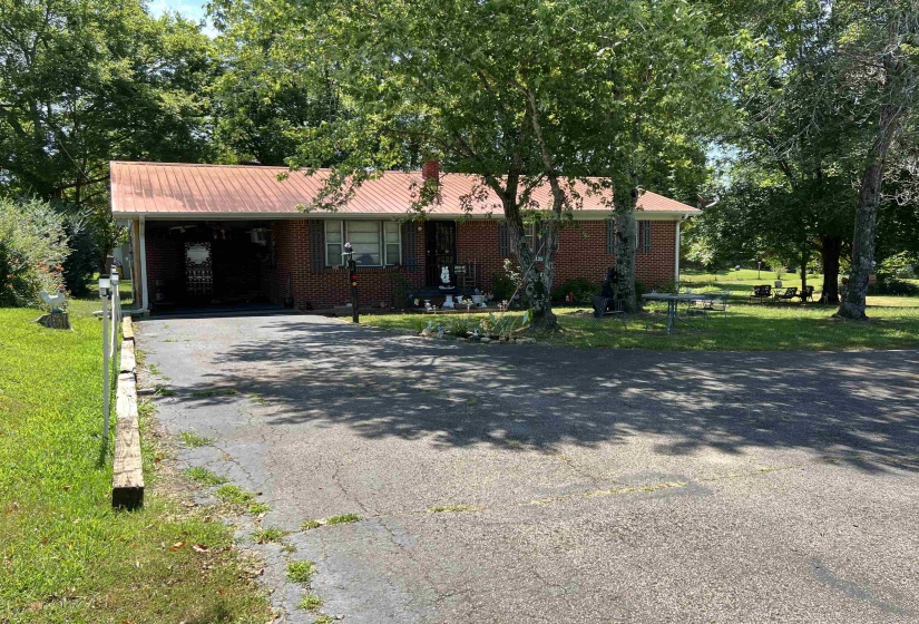Single story home with a carport and a front yard
