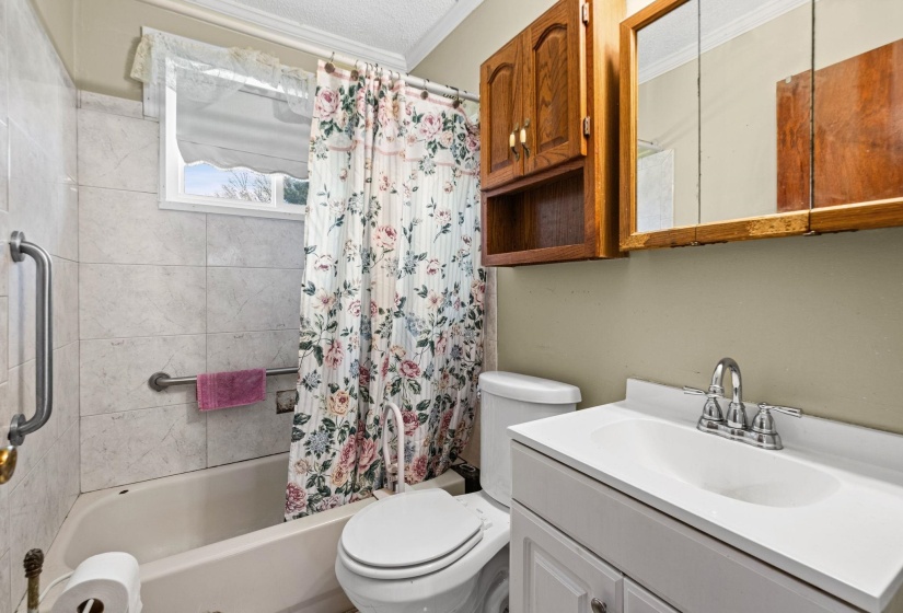 Full bath with vanity, crown molding, and shower / tub combo with curtain