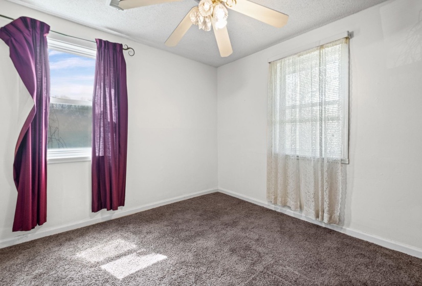 Empty room with carpet, ceiling fan, and a textured ceiling