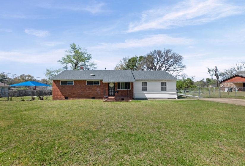 View of front of home with crawl space, brick siding, and a chimney