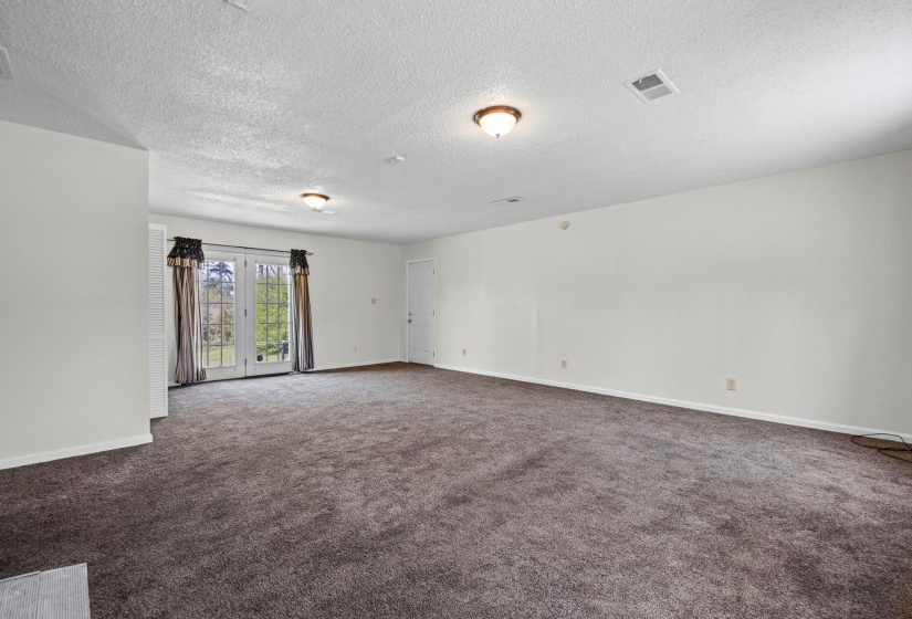 Unfurnished room featuring carpet and a textured ceiling