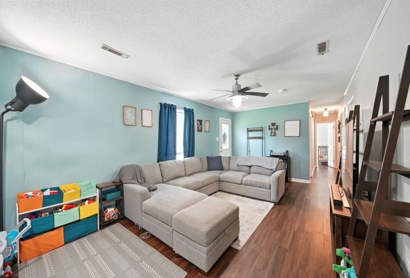 Living room with wood finished floors, a textured ceiling, and ceiling fan