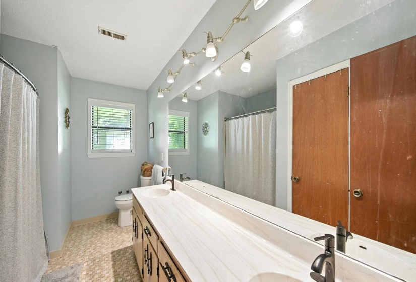 Bathroom featuring double vanity and curtained shower