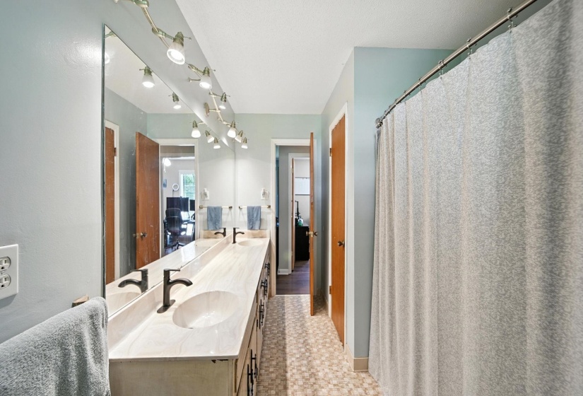 Full bath featuring double vanity and ensuite bath