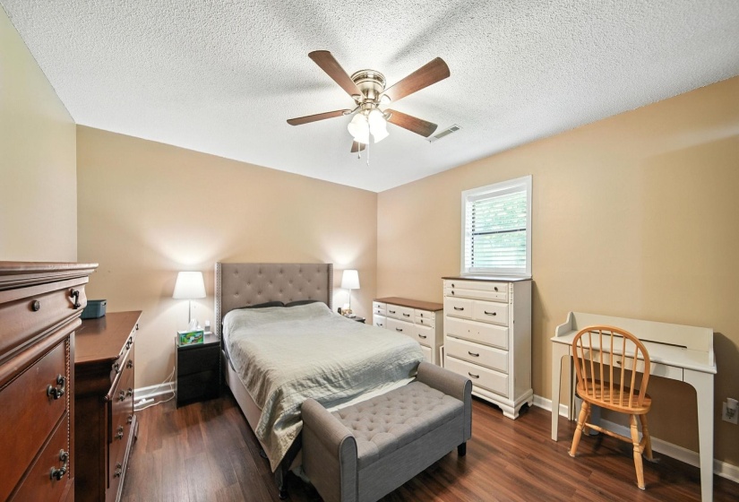 Bedroom featuring dark wood-style floors, a textured ceiling, and a ceiling fan