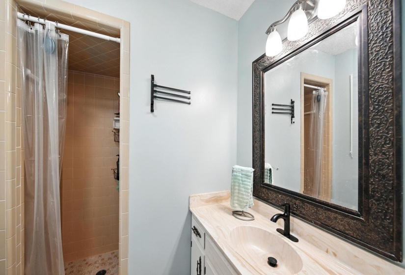 Full bath with vanity and a tile shower