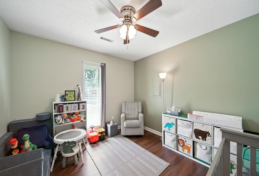 Bedroom featuring ceiling fan, wood finished floors, and a textured ceiling