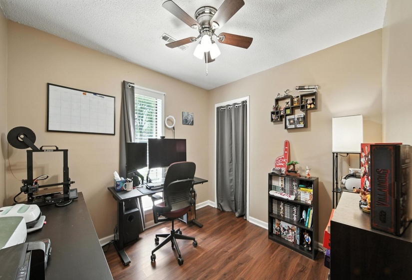 Bedroom featuring ceiling fan, wood finished floors, and a textured ceiling