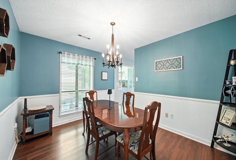 Dining area featuring wood finished floors, a chandelier, and a textured ceiling