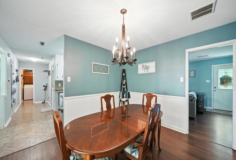 Dining room with wood finished floors, a chandelier,  and a textured ceiling