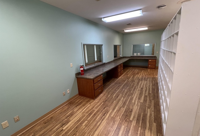 Unfurnished office featuring baseboards, dark wood-style flooring, built in study area, and vaulted ceiling