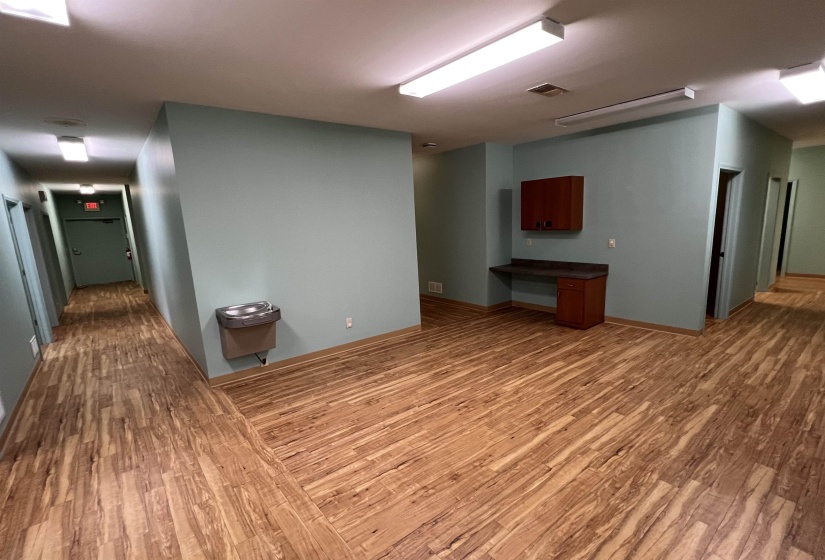 Basement with baseboards, visible vents, and wood finished floors