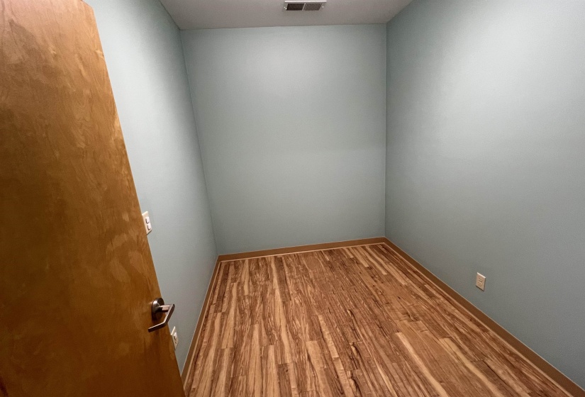 Empty room with baseboards, visible vents, and wood finished floors