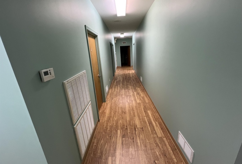 Hall with visible vents and wood finished floors