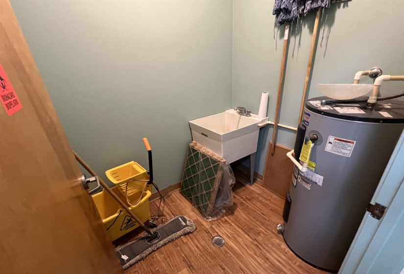 Utility room featuring a sink and electric water heater