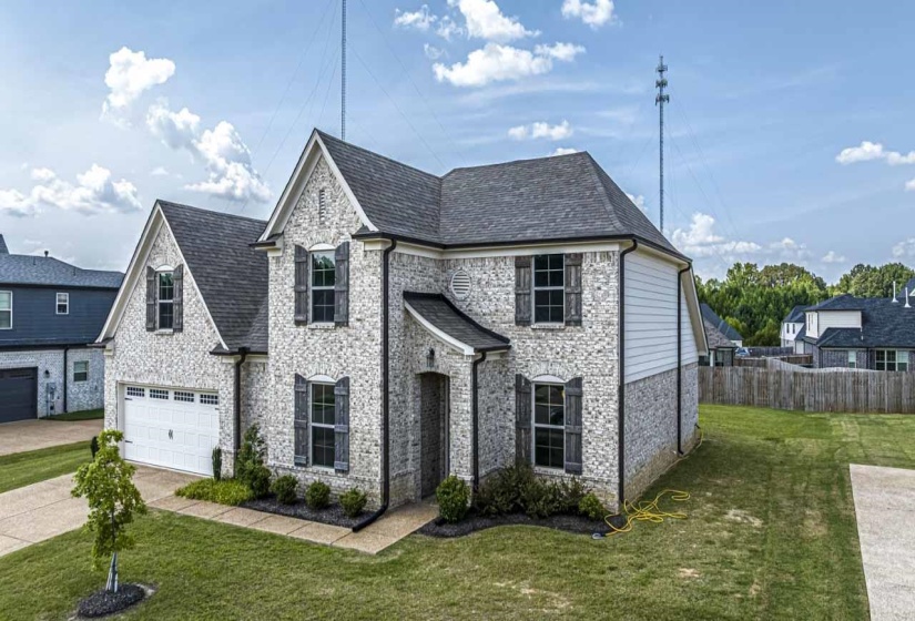 French country home with concrete driveway, a garage, stone siding, and brick siding