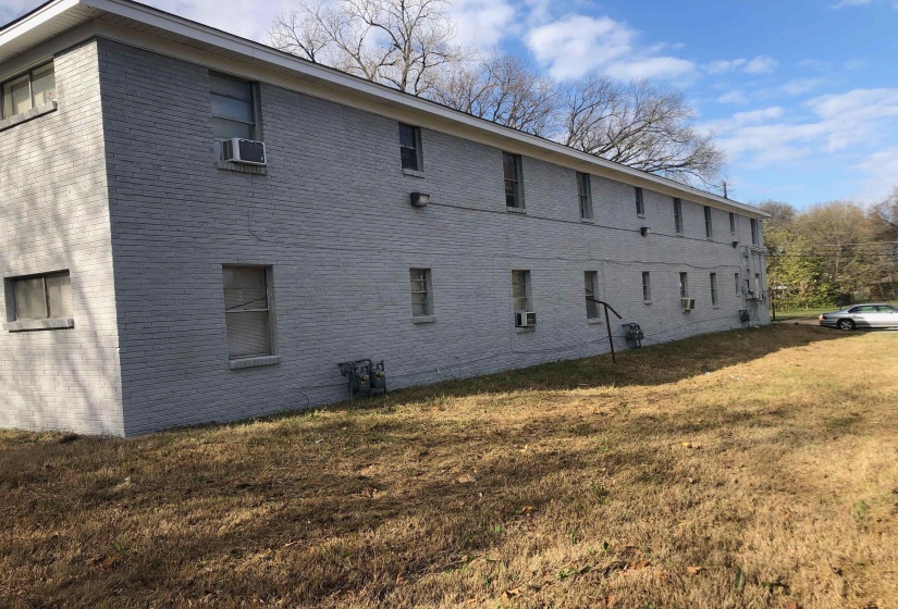View of home's exterior with brick siding, a yard, and cooling unit