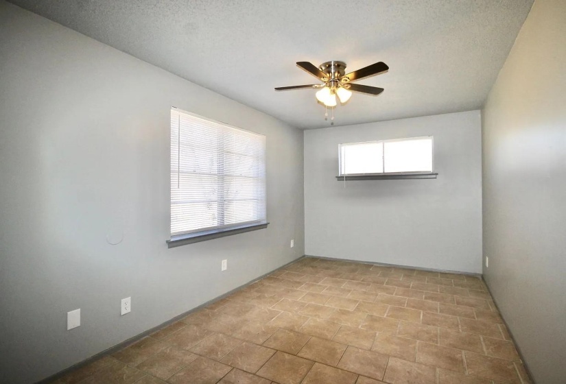 Empty room featuring a ceiling fan, baseboards, and a textured ceiling
