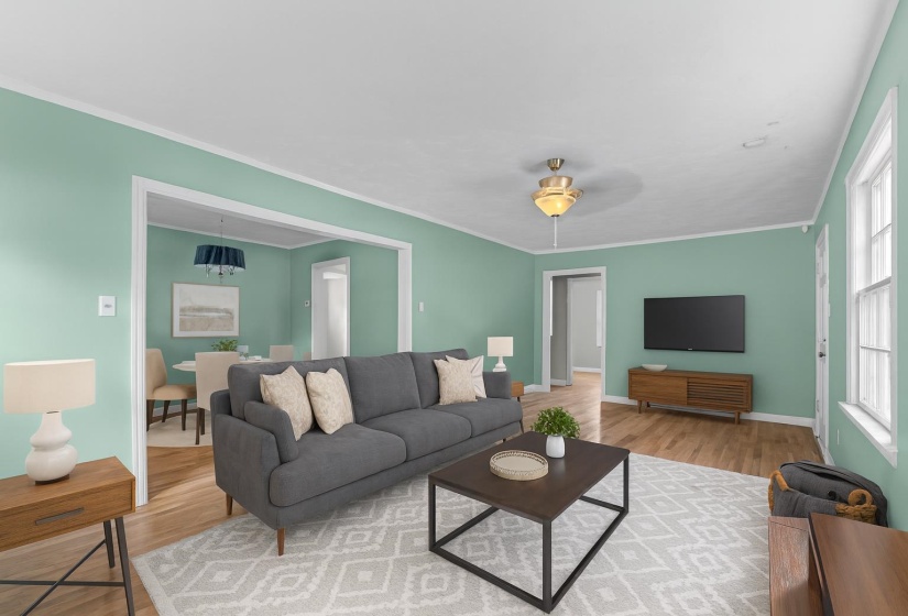 Step into a living space that instantly feels like home. This inviting living room is bathed in natural light and features beautiful hardwood floors, and classic trim accents. This room has been virtually staged.