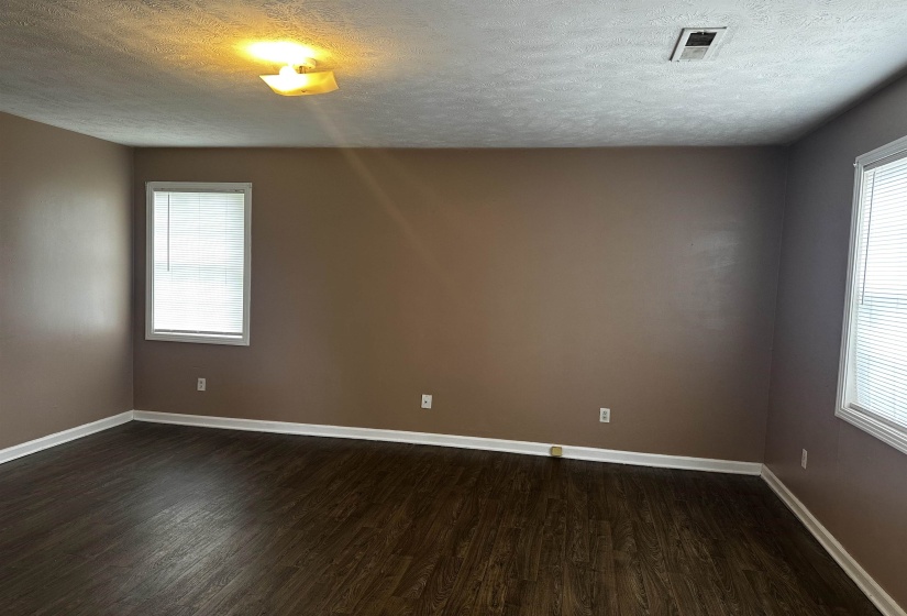 Empty room with dark wood-style flooring and a textured ceiling
