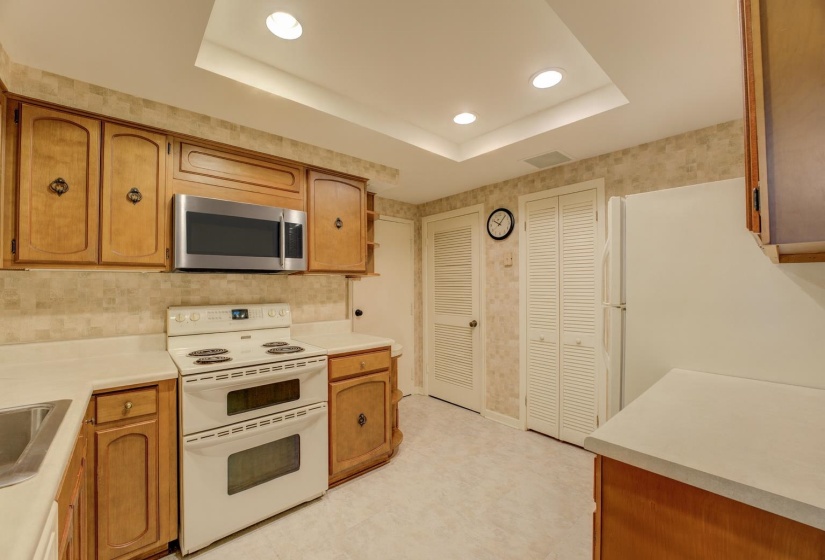 Featuring recessed lighting, a spacious pantry, and a full complement of appliances—including a double oven, brand new stainless steel microwave, dishwasher, and sink—it’s the perfect place to prepare meals with ease and style.