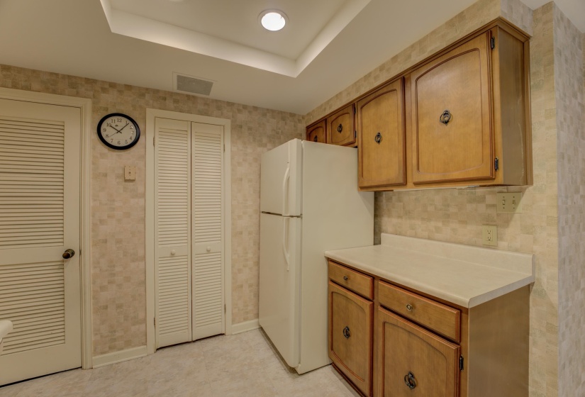 Another view of the kitchen with a refrigerator.