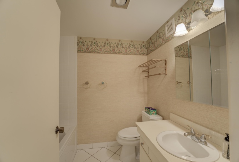 Full bath with tile patterned floors and vanity.
