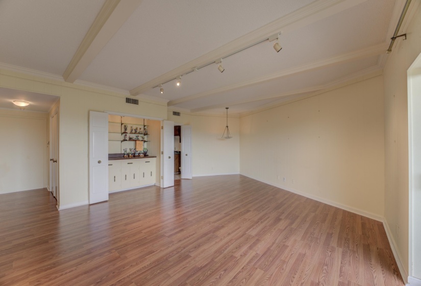 Featuring warm hardwood floors, a bar, and a kitchenette with refrigerator, this room’s neutral palette and balcony access through double glass doors make it an excellent third bedroom, den, or mother-in-law suite.