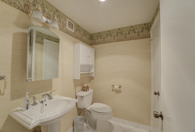 Bathroom with tile patterned flooring, walk-in shower, and wallpapered walls.