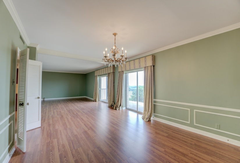 Hardwood floors add warmth, while the dining area’s chandelier and chair rail bring classic charm. Two sets of sliding glass doors open to a large balcony, extending your entertaining space into the fresh air.
