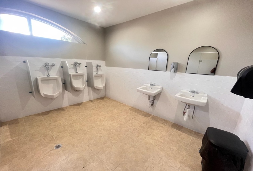 Bathroom featuring tile walls, a wainscoted wall, and a bidet