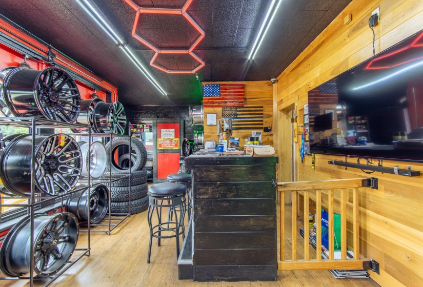Bar area with light wood-style flooring and wood walls