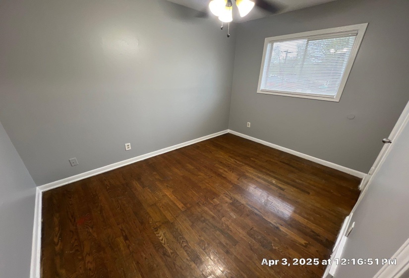 Spare room with dark wood-style floors and a ceiling fan