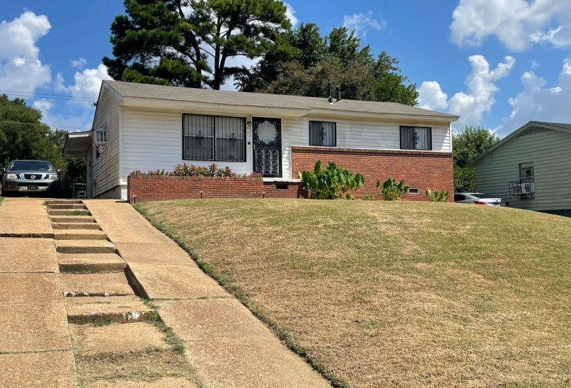 View of front facade with brick siding and a front yard