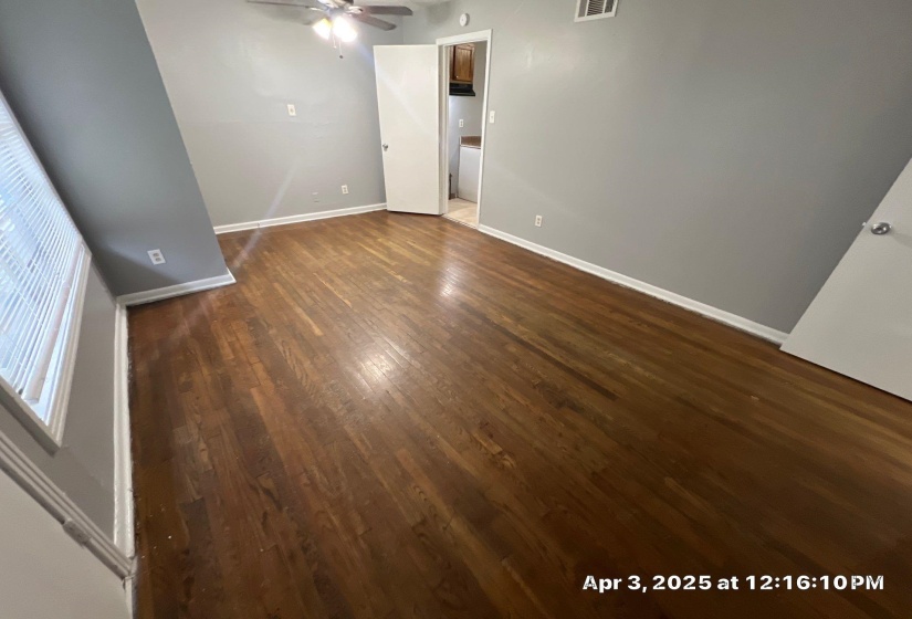 Unfurnished room with dark wood finished floors and a ceiling fan