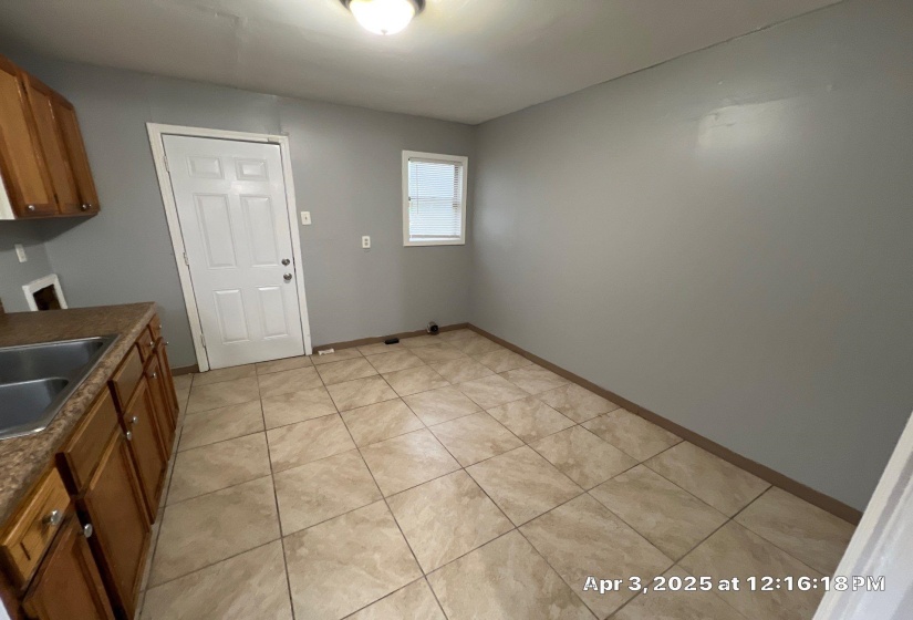 Kitchen featuring brown cabinets, dark countertops, and light tile patterned floors