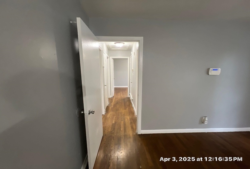 Hall with dark wood-style flooring and attic access