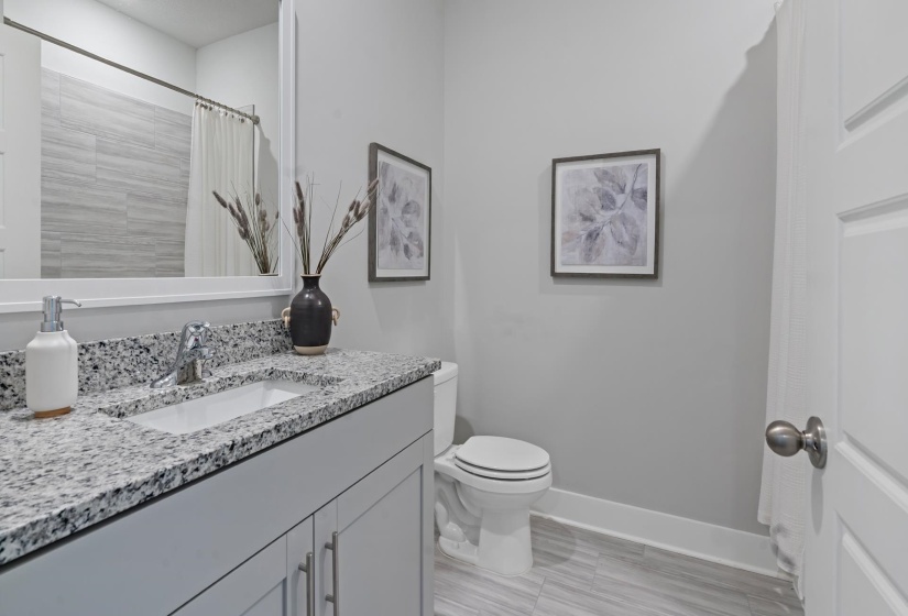 Bathroom with a shower with curtain, vanity, and toilet