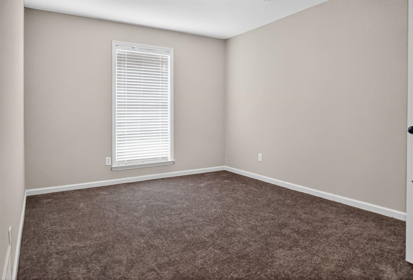 Empty room with dark carpet and baseboards