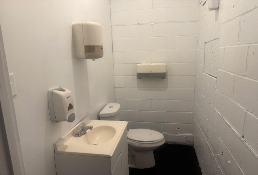 Half bathroom featuring vanity and concrete block wall