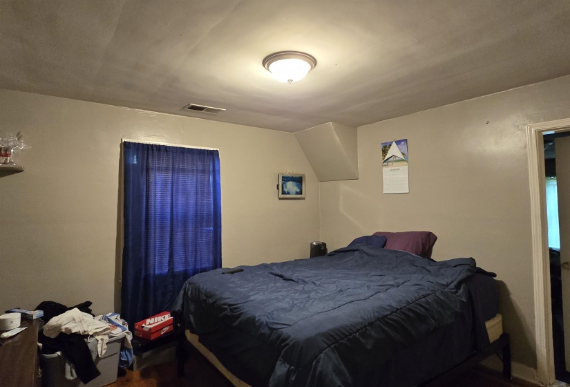 Bedroom with dark wood-type flooring